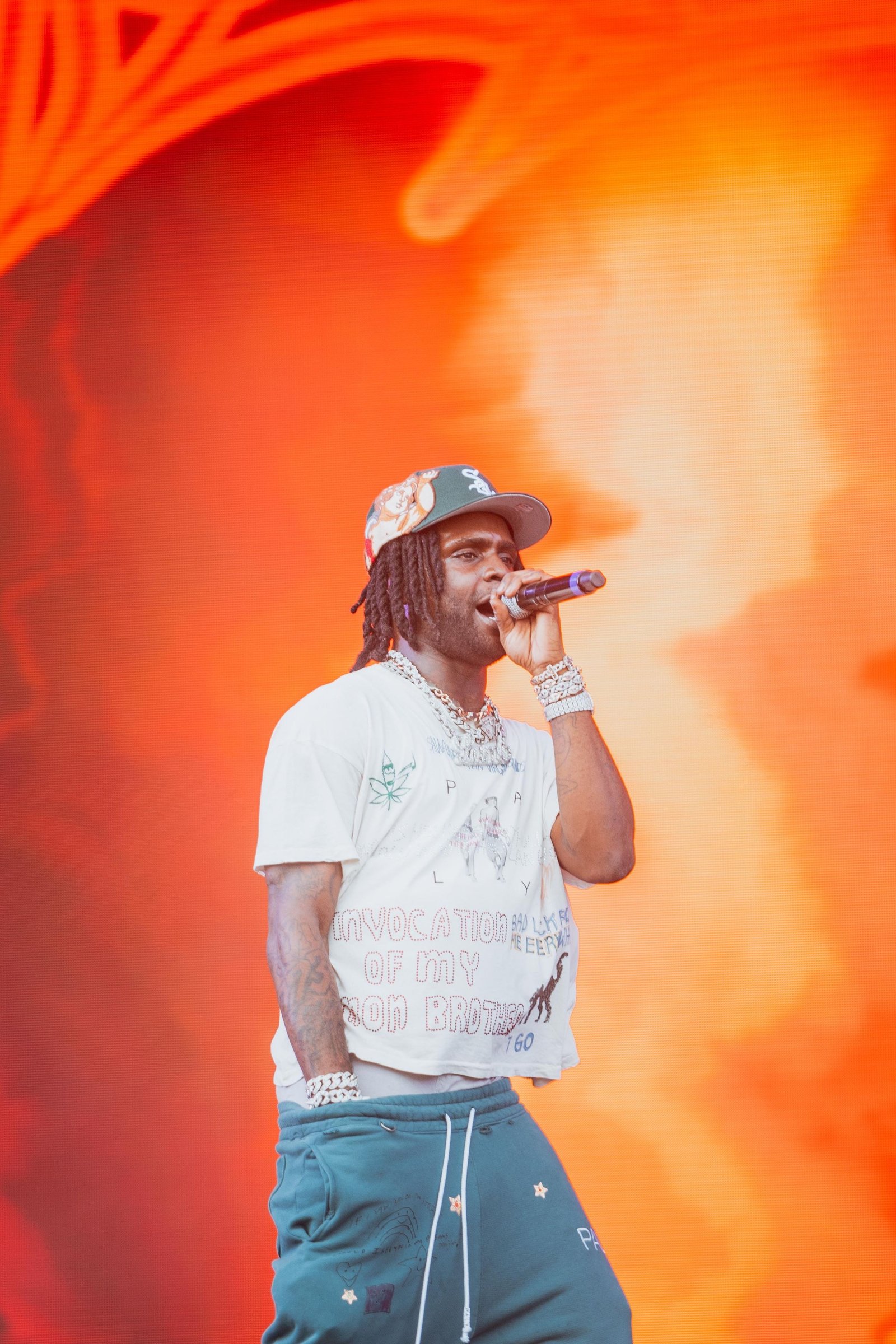 A performer on stage in front of orange stage lighting.